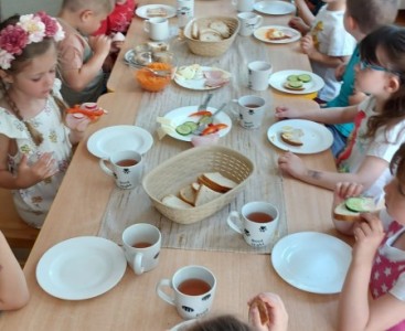 Dzieci jedzą przygotowane artystyczne kanapki. - powiększ