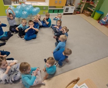 Dzieci z grupy 'Biedronek' na zdjęciu grupowym ubrane na niebiesko, ustawione w kształcie serca.  - powiększ