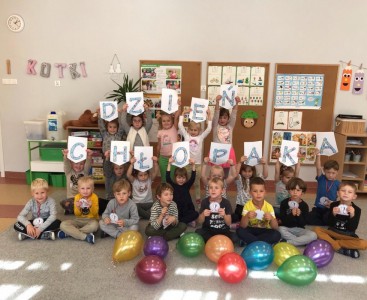'Kotki' na zdjęciu grupowym z napisem 'Dzień Chłopaka' oraz balonami. - powiększ