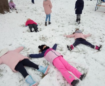 Dzieci z gr. Myszki podczas zabawy na śniegu w przedszkolnym ogrodzie.  - powiększ