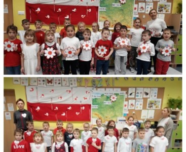 Zdjęcie przedstawia dzieci ubrane w barwy biało-czerwone z biało-czerwonymi kwiatami w ręku, które odśpiewują hymn. Wszystko to zaprezentowane jest na tle flagi Polski. - powiększ