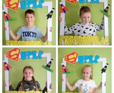 Zdjęcie wykonane w formie kolażu, w którym czwórka dzieci pozuje do zdjęcia w drewnianej ramce z napisem SUPER PRZEDSZKOLAK i swoim imieniem.  - powiększ