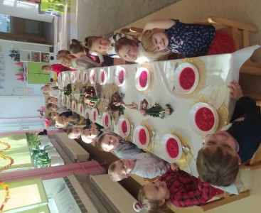 Dzieci z grupy 'Pszczółek' podczas uroczystego posiłku prze wspólnym stole. - powiększ